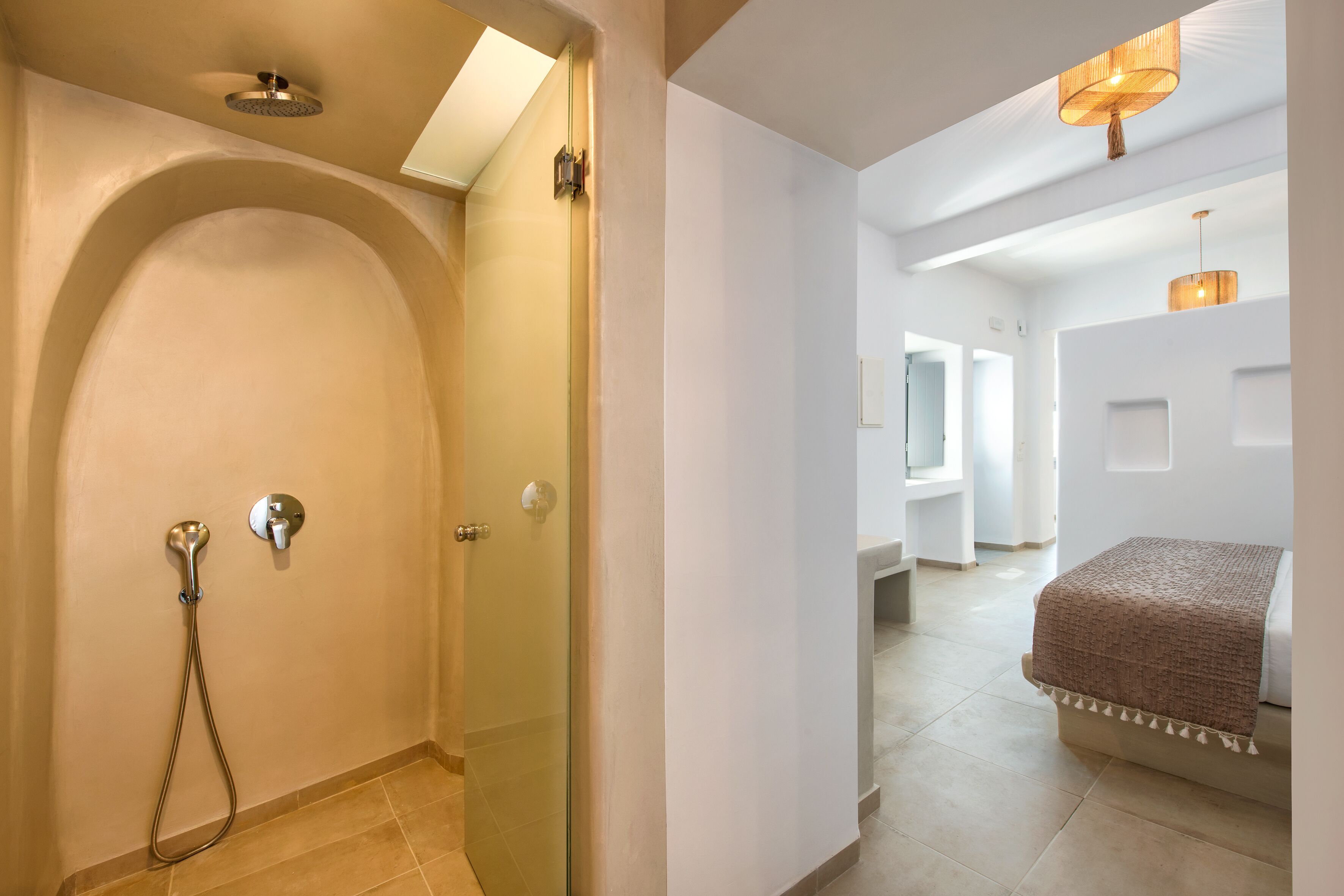 A modern bathroom with a glass shower enclosure, a towel rack, and a ceiling light fixture.