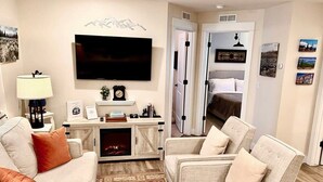A living room with a fireplace, a television, and a sofa.