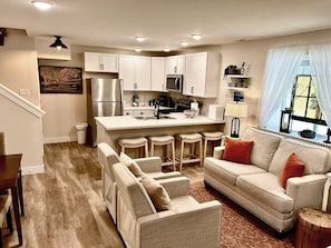 A modern kitchen with white cabinets, a stainless steel refrigerator, and a bar area with stools. - 2BR Mountain Retreat - Near Mineral Trail, Balcony (Leadville)