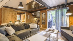 Un accogliente soggiorno con divano, tavolino e una scala che conduce a un balcone.