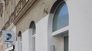 Un edifici amb façana blanca, finestres d'arc i una entrada visible amb escales.