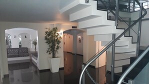Un intérieur moderne avec un escalier, un canapé et une plante en pot.