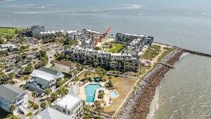 An aerial view of a coastal hotel with multiple buildings, a swimming pool, and a rocky shoreline. - Oceanview, steps from Beach, Pool, Golf course & Restaurant, newly remodeled.  (Saint Helena Island)