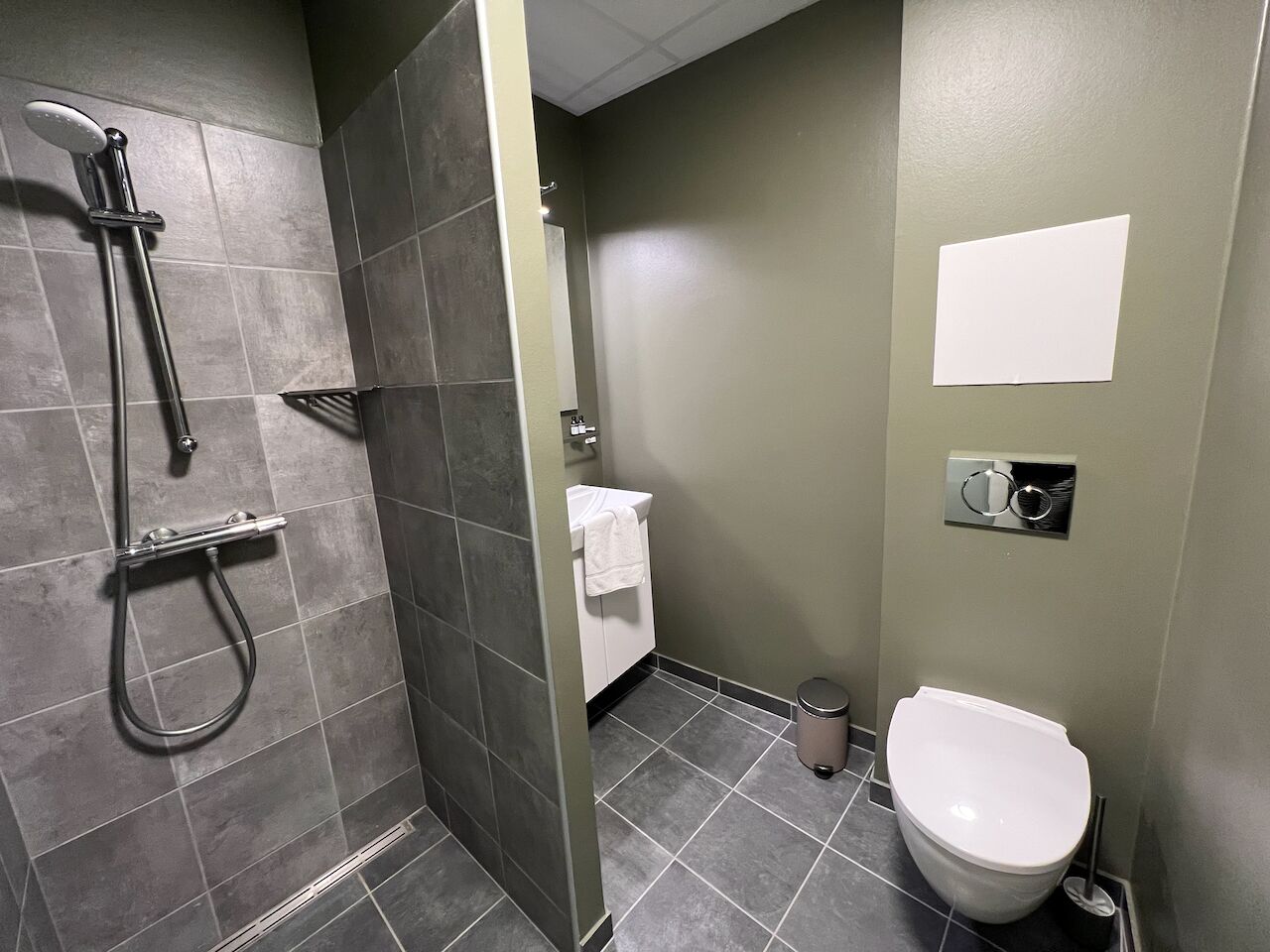 A bathroom with a shower, toilet, and sink.