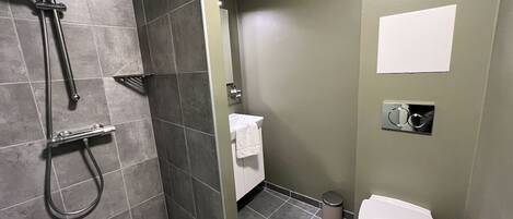 A bathroom with a shower, toilet, and sink.