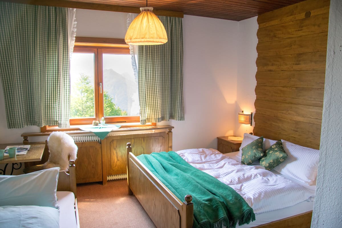Une chambre à coucher avec un lit en bois, un bureau et une chaise.