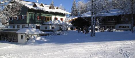 A snow-covered building with a traditional architectural style, including a sloped roof and wooden exterior.