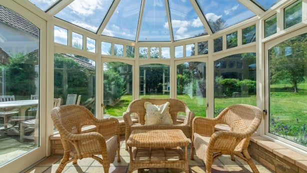 A conservatory with wicker furniture and large windows. - Beacon Lodge, Burnham Market, Norfolk (Burnham Market)