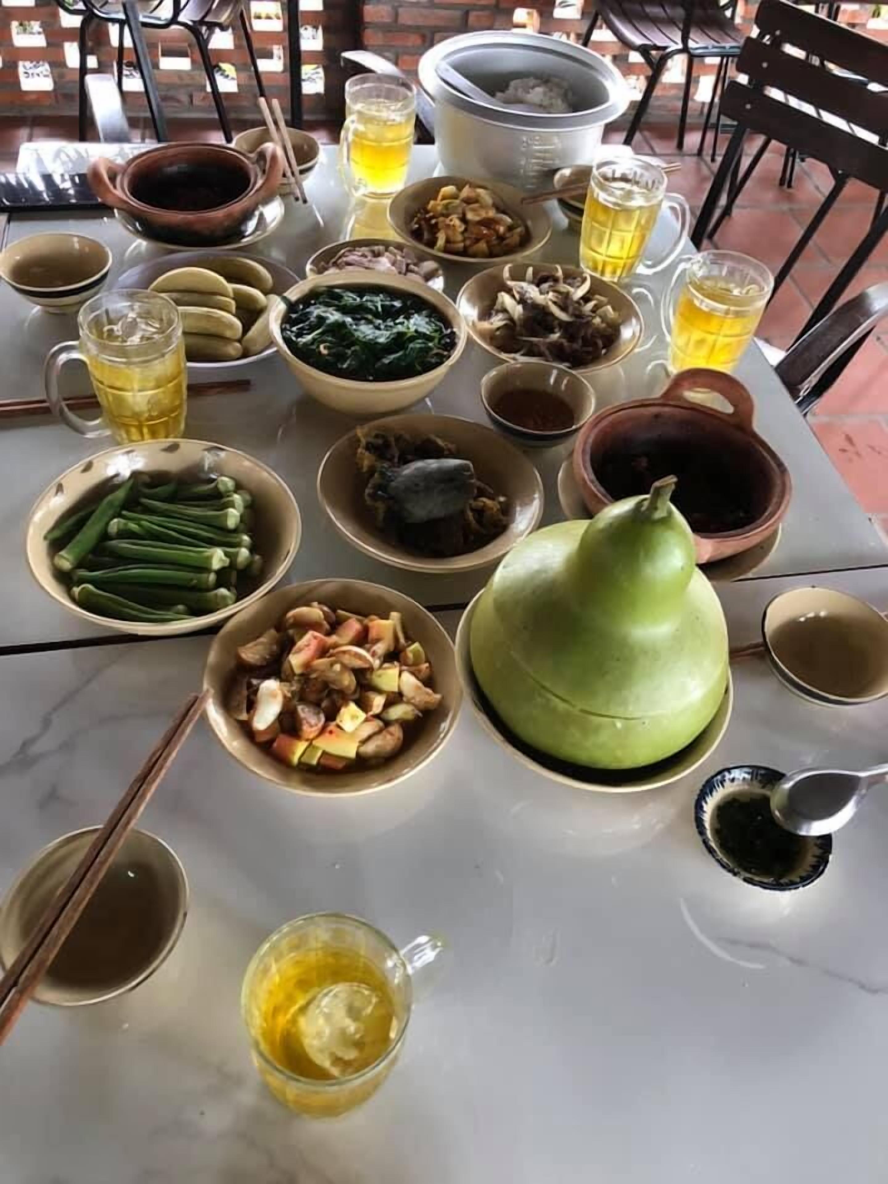 Una mesa dispuesta con diferentes platos, bebidas y utensilios, sugiriendo una preparación para comer.