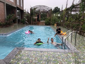 A swimming pool with tiled edges, a brick wall, and a pergola structure. - Bau Bi Mini Farmstay Mekong - Tien Giang (Trung An)