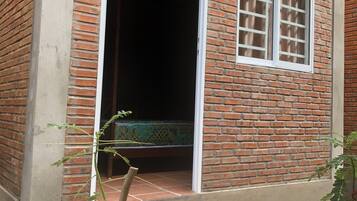 A brick building with a large open doorway leading to a dark interior.