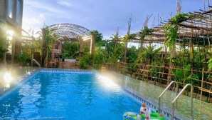 An indoor swimming pool with a glass barrier, surrounded by lush greenery and a covered walkway. - Bau Bi Mini Farmstay Mekong - Tien Giang (Trung An)