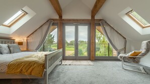 Ein Schlafzimmer mit einem Bett, einem Sessel und einem großen Fenster.