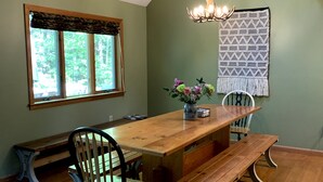 A dining area with a wooden table, benches, and chairs.