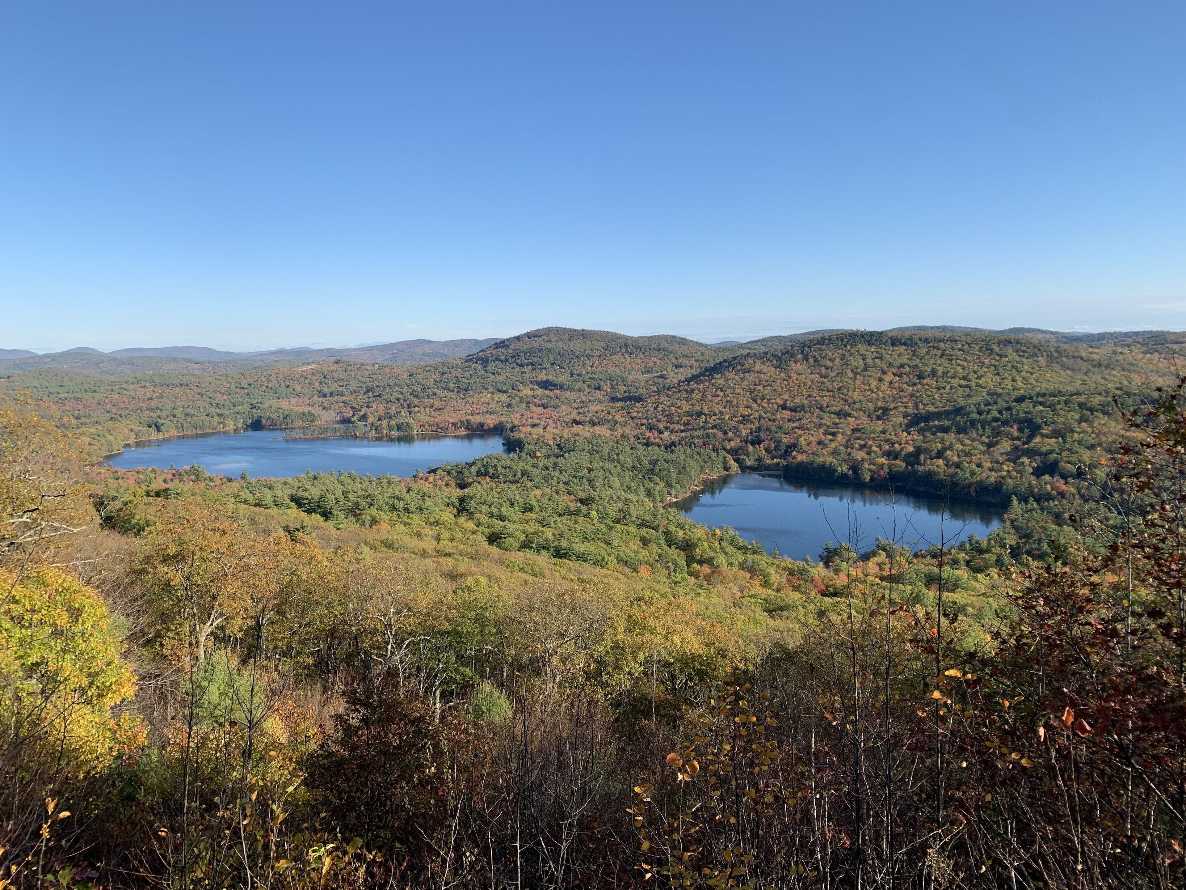 A mountainous landscape with two lakes surrounded by dense forests.