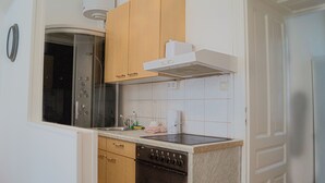 Una cocina compacta con lavavajillas, estufa y armarios de madera.