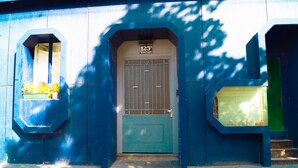 A blue building with a door marked "123" and two windows with flower boxes.