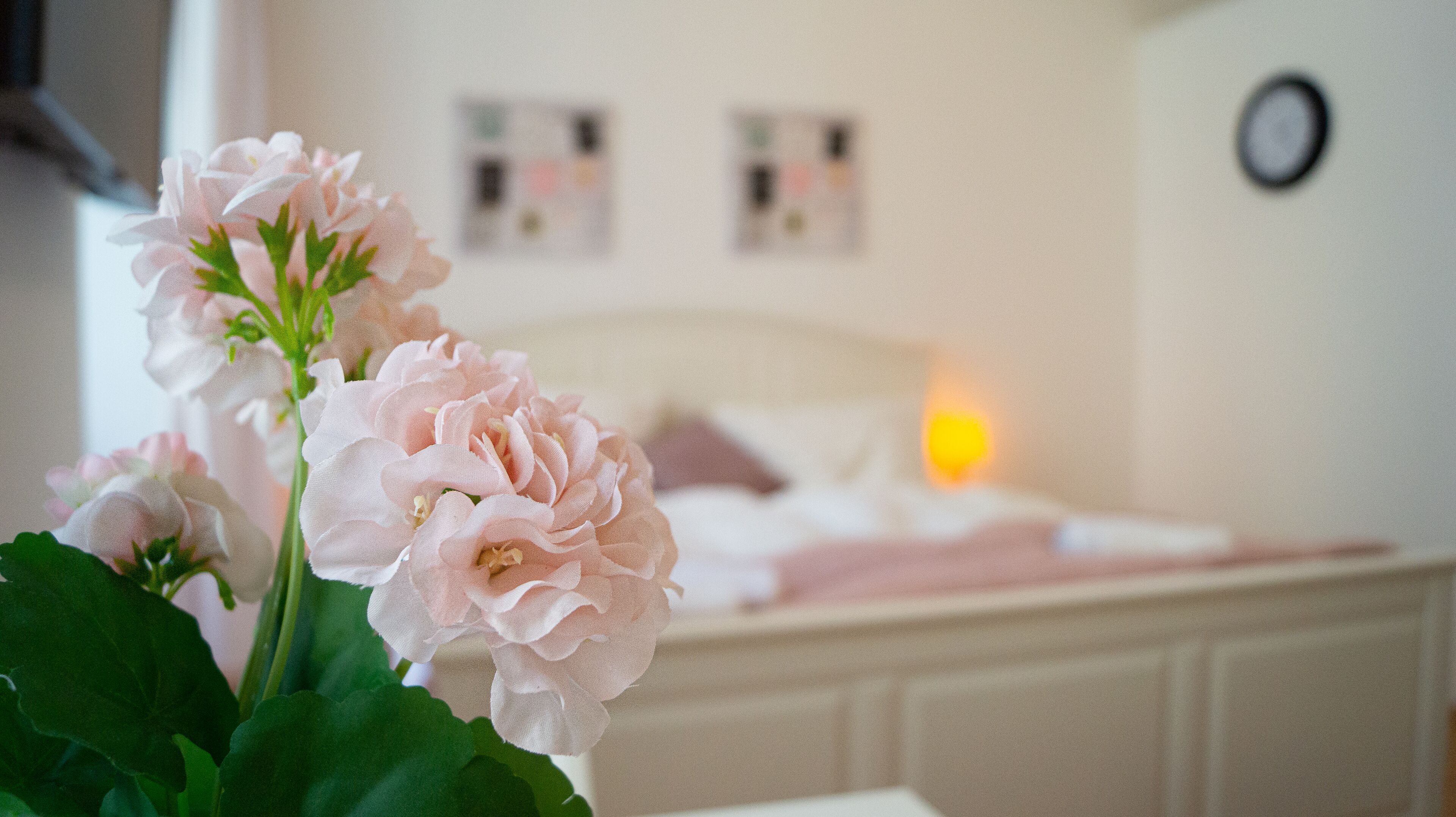 Ein Schlafzimmer mit einem Bett, einem Nachttisch und einer Wanduhr.