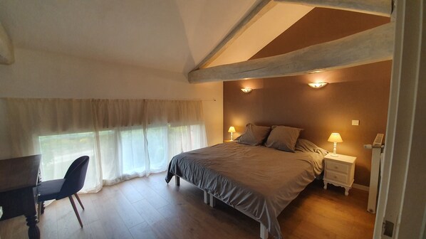 A bedroom with a bed, two bedside lamps, a chair, and a window with sheer curtains. - La Prunelière, in the heart of nature (Razines)
