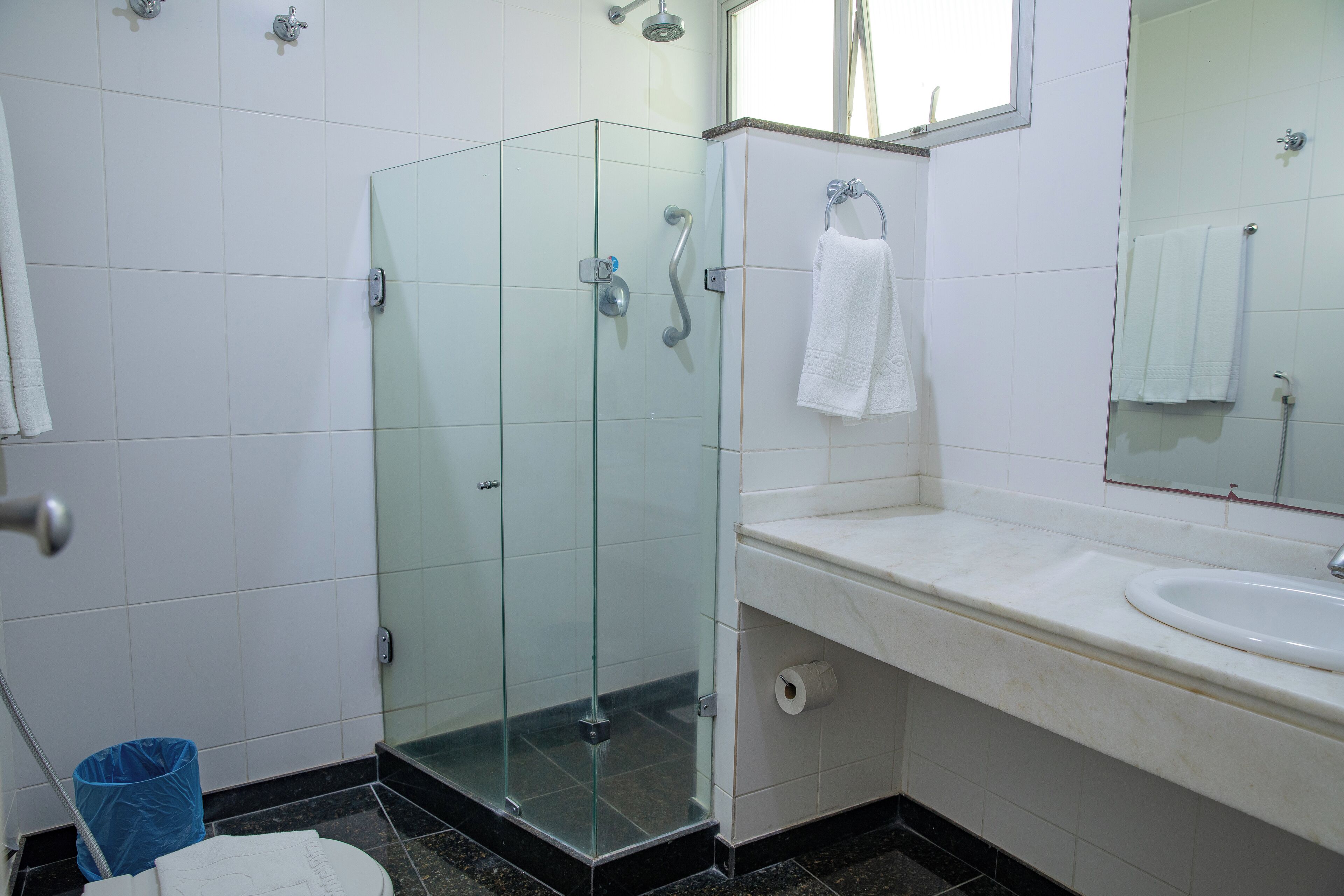 Un baño con cabina de ducha de vidrio, un lavabo y un espejo.