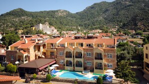 Un hotel con varios pisos, balcones y piscina.