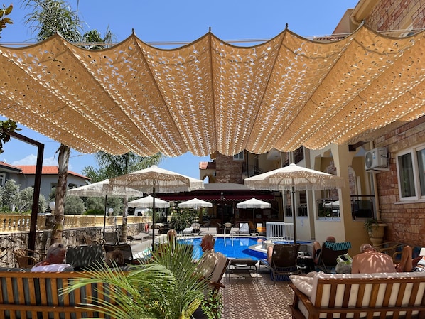 A poolside area with lounge chairs, umbrellas, and a pool. - Gozdem Apart 2 (Marmaris)