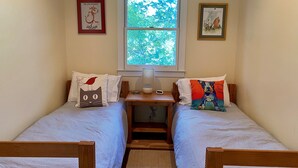 A room with two single beds, a window, a desk, and a lamp. - The Pill Box is the perfect getaway next to the Cowpasture River (Millboro Springs)