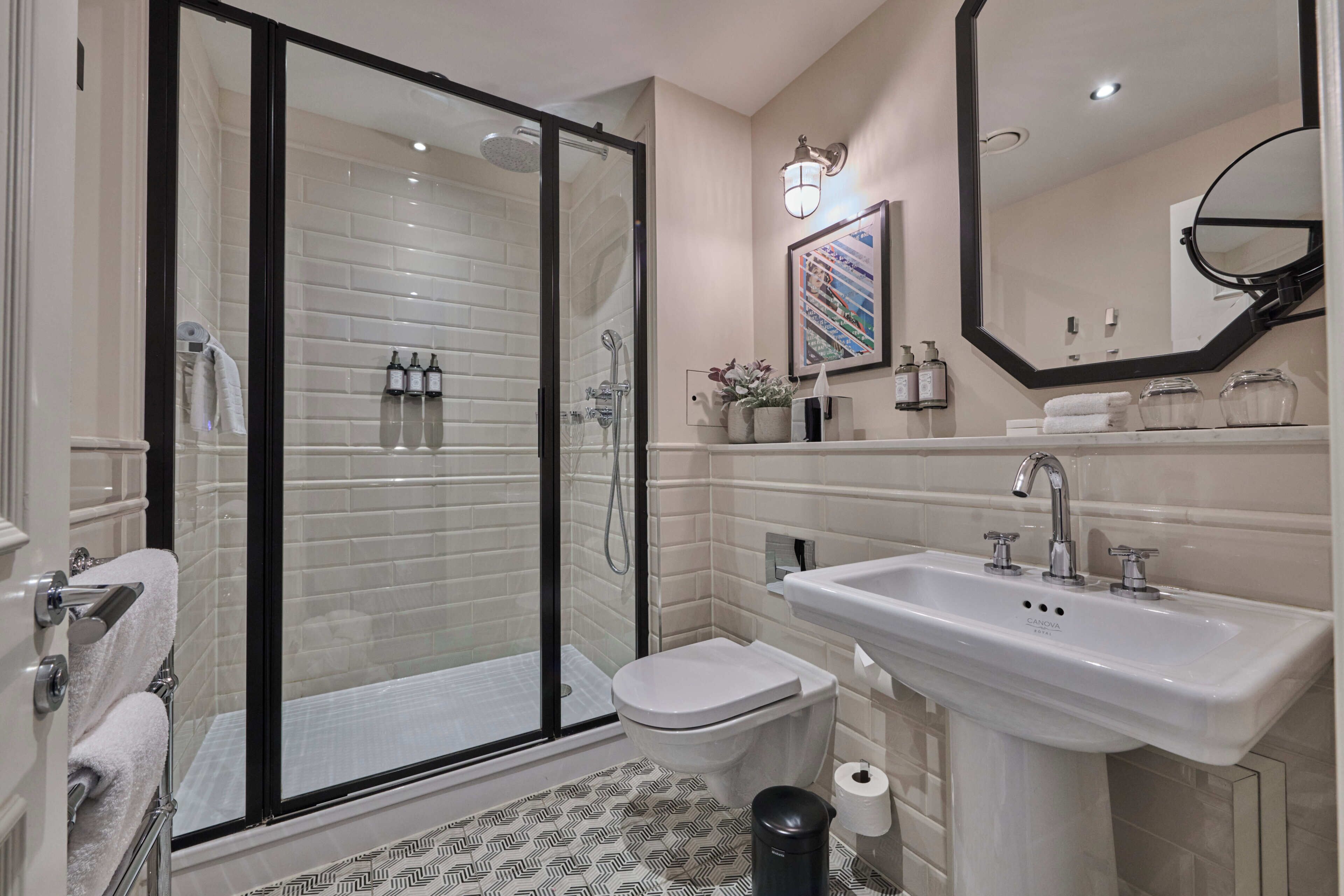 Une salle de bain moderne avec une douche à parois de verre, un lavabo blanc et des toilettes.