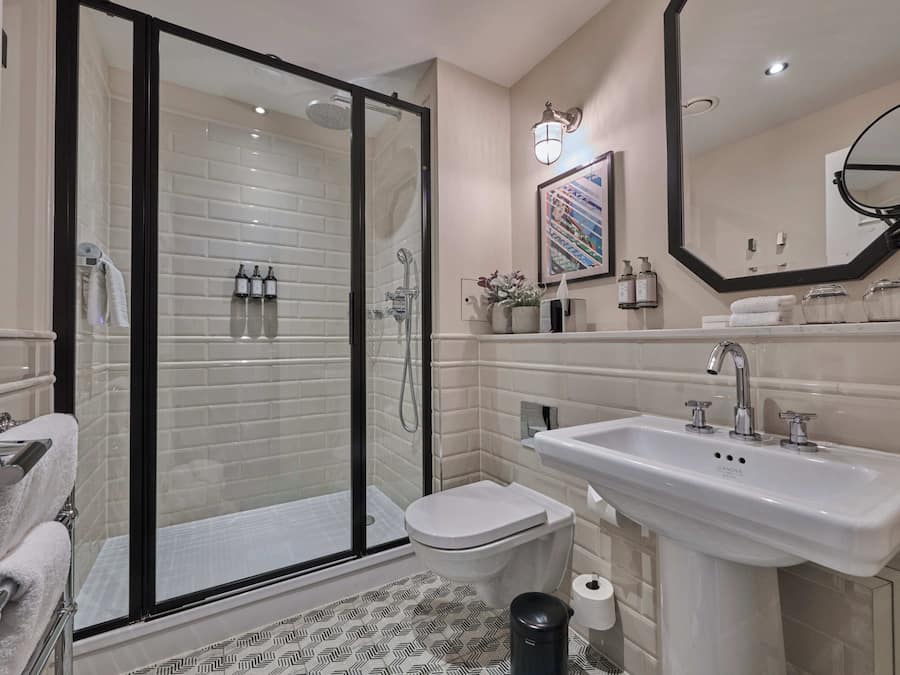 A modern bathroom with a glass-enclosed shower, a white sink, and a toilet.