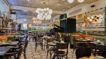 A spacious restaurant with multiple dining areas, a bar, and a piano.