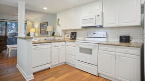A kitchen with white cabinets, a stove, and a dishwasher. - Hilton Head Beach Club - 3 Bedroom w/ a Private Patio! (Hilton Head Island)