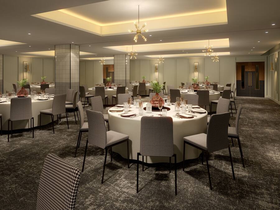 Una amplia sala de conferencias con mesas redondas, sillas a cuadros en blanco y negro y modernos candelabros.