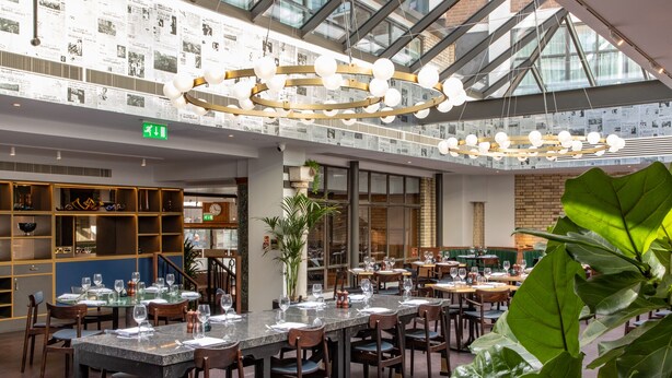 A spacious indoor dining area with multiple tables and chairs, a large plant, and a ceiling with hanging spherical lights. - Telegraph Hotel - Coventry (Coventry)
