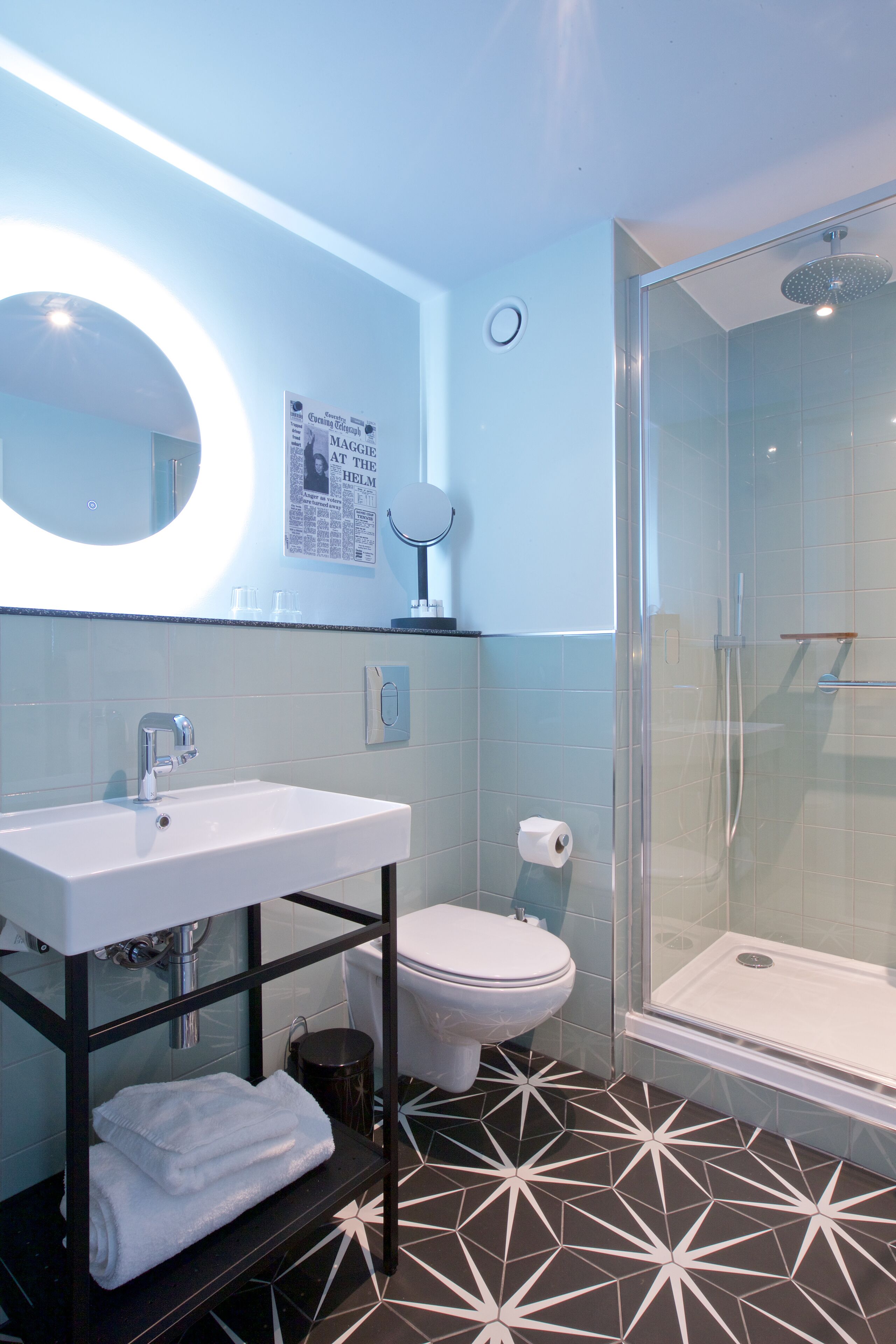 A modern bathroom with a white sink, toilet, and glass-enclosed shower.