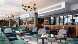 A modern lobby with green sofas, a bar area, and a staircase. - Telegraph Hotel - Coventry (Coventry)
