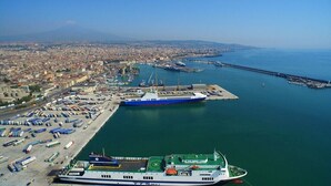 Un ferry atracado en un puerto, con un paisaje urbano al fondo.