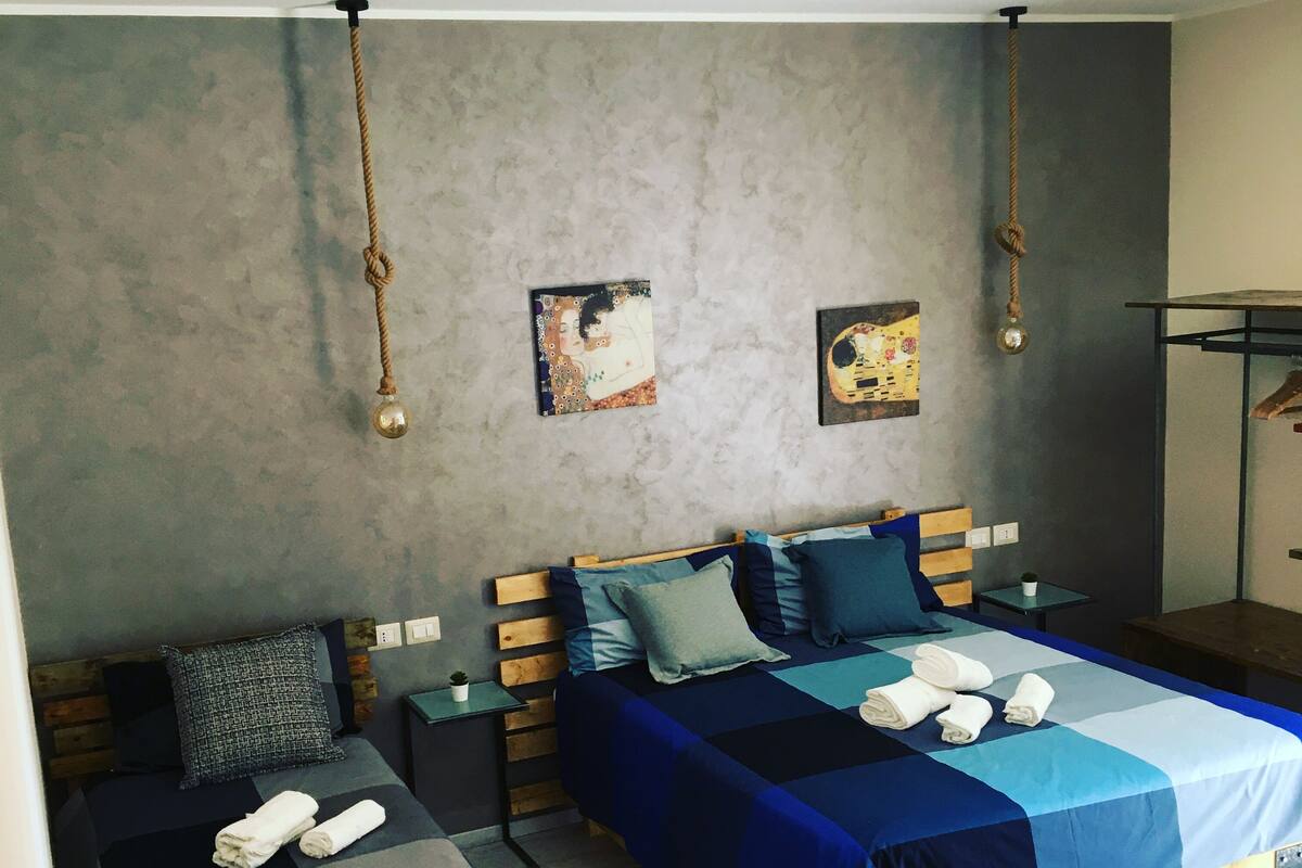Un dormitorio moderno con dos camas, una mesita y una mesita de noche.