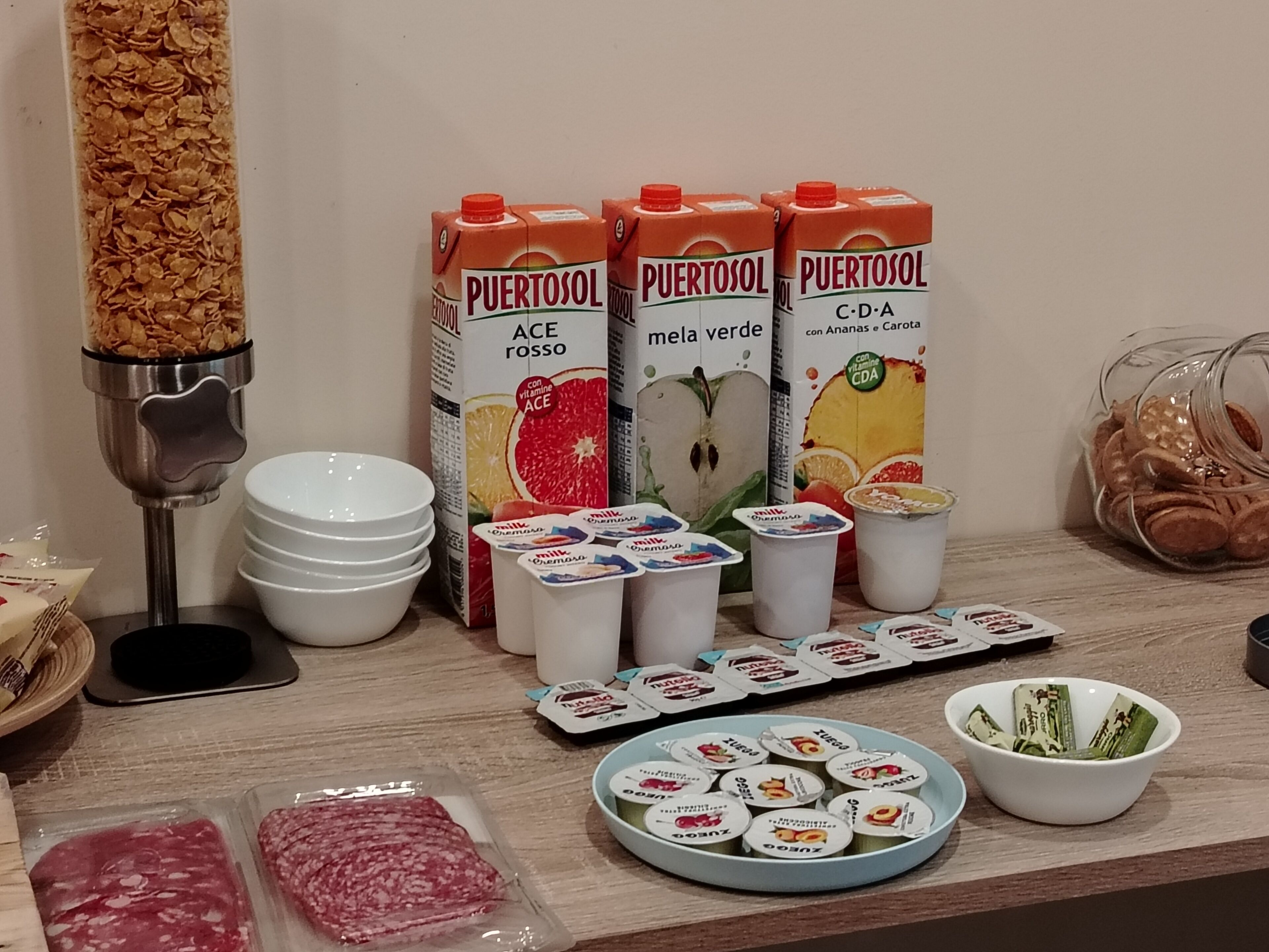 A breakfast setup with cereal, milk cartons, yogurt cups, and meat packages.