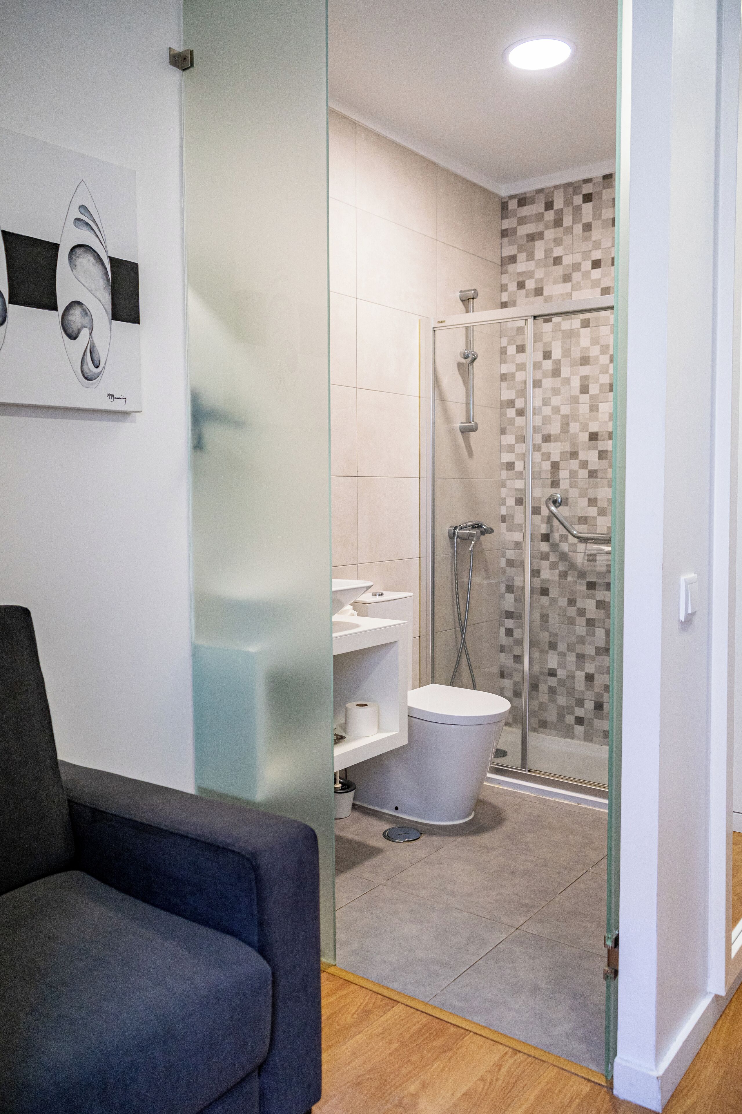 Un baño moderno con cabina de ducha de vidrio, inodoro y lavamanos.