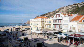 Un pueblo costero con edificios, una playa y una ladera rocosa.