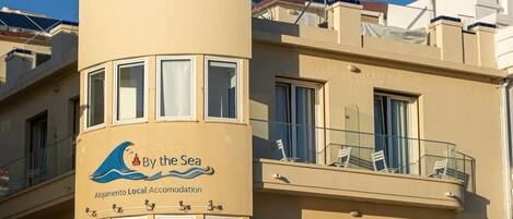 A building with a sign reading "By the Sea" indicating a local accommodation.