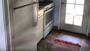A kitchen with a refrigerator, stove, oven, and a window. - The Terrace House, country living. (Montgomery Creek)