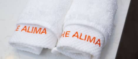 Two white towels with embroidered text on a white surface.