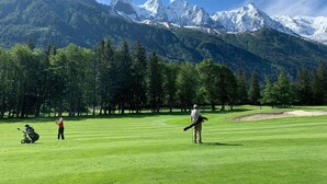 A golf course with a mountainous backdrop.
