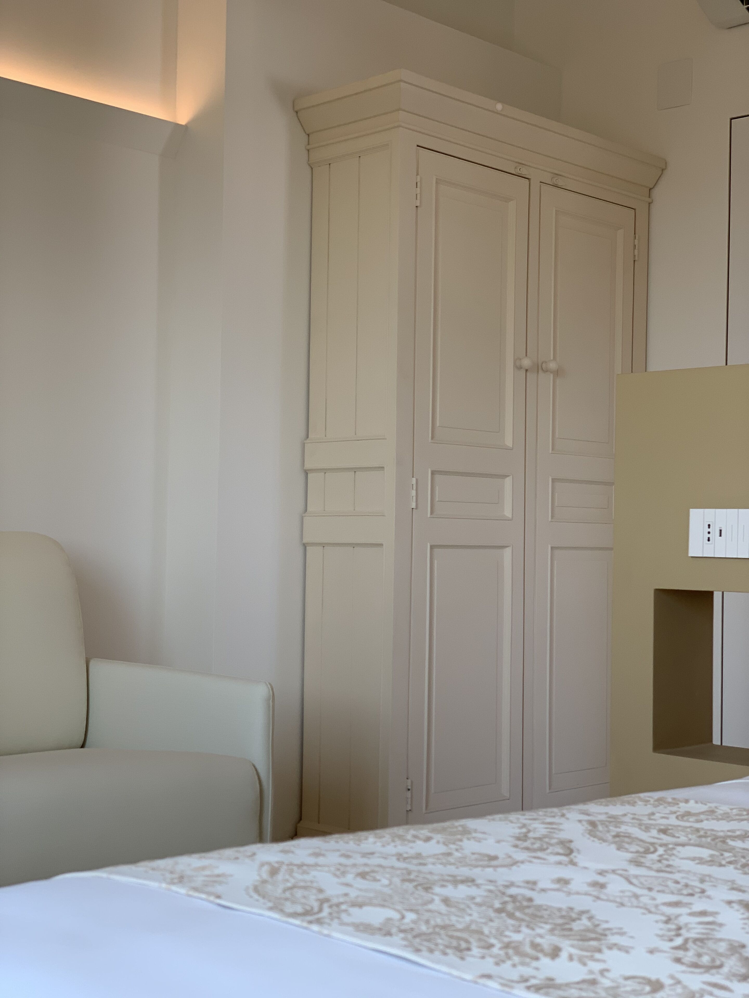 Une chambre à coucher avec un lit, une armoire et une chaise.