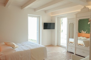 A bedroom with a bed, a TV mounted on the wall, and a wardrobe.