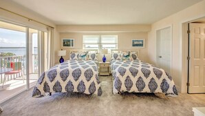A bedroom with two beds, a balcony, and a view of the sea. - Vacation Villas #535 Cozy Beachfront Condo (Fort Myers Beach)