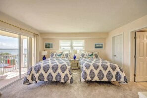 A bedroom with two beds, a balcony, and a view of the sea. - Vacation Villas #535 Cozy Beachfront Condo (Fort Myers Beach)