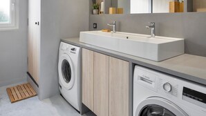 Un lavadero moderno con lavadora, secadora y lavamanos.