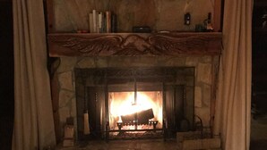 A fireplace with a bear painting above it, a mantel with books, and a rug on the floor. - Bear Gone Fishing- Cool Down in the Creek!!! Mins to Highlands (Scaly Mountain)